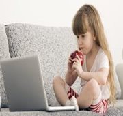 A little girl sitting at a laptop